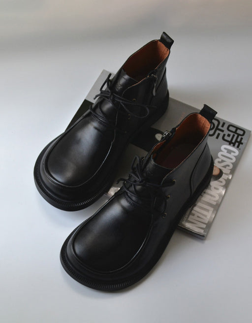 A pair of black leather lace-up boots for men, displayed against a white background.