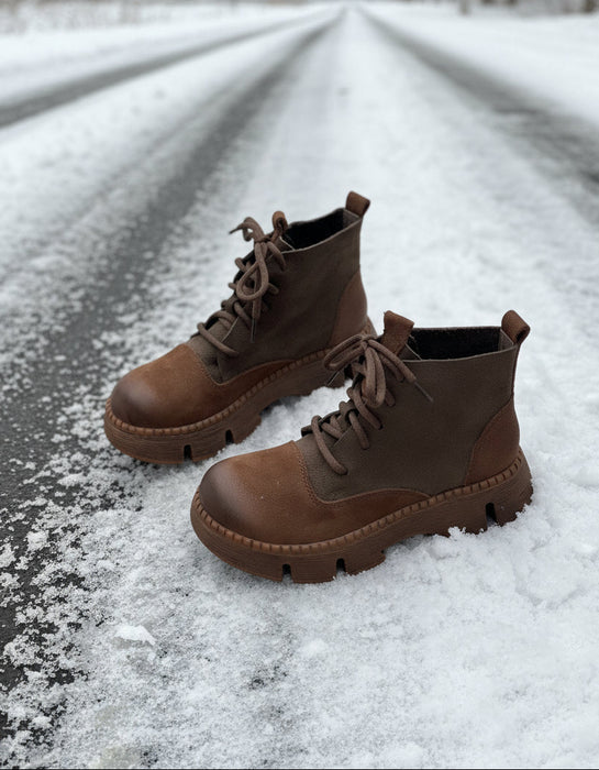 Pair of brown leather boots on a light gray background