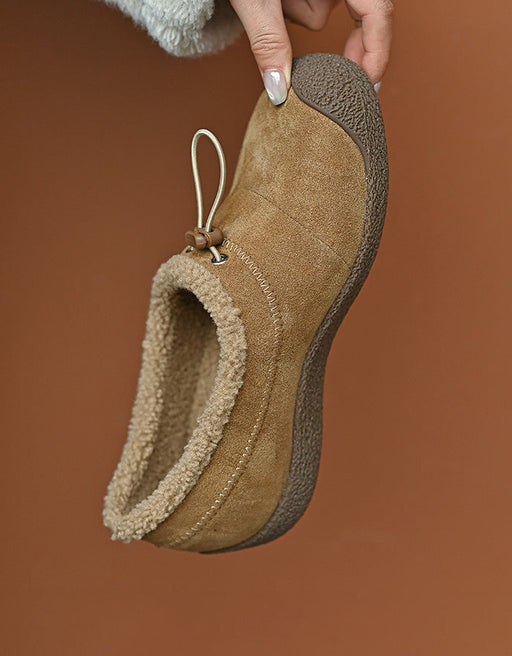 Brown slipper being held against a brown background