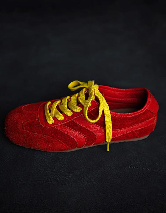 Red shoe with yellow laces on a black background