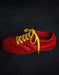 Red shoe with yellow laces on a black background