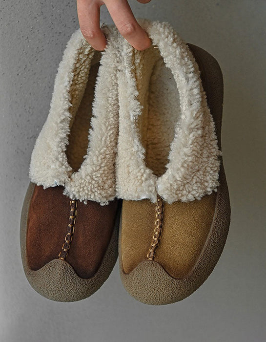 Pair of brown and beige slippers with white fuzzy trim held against a neutral background