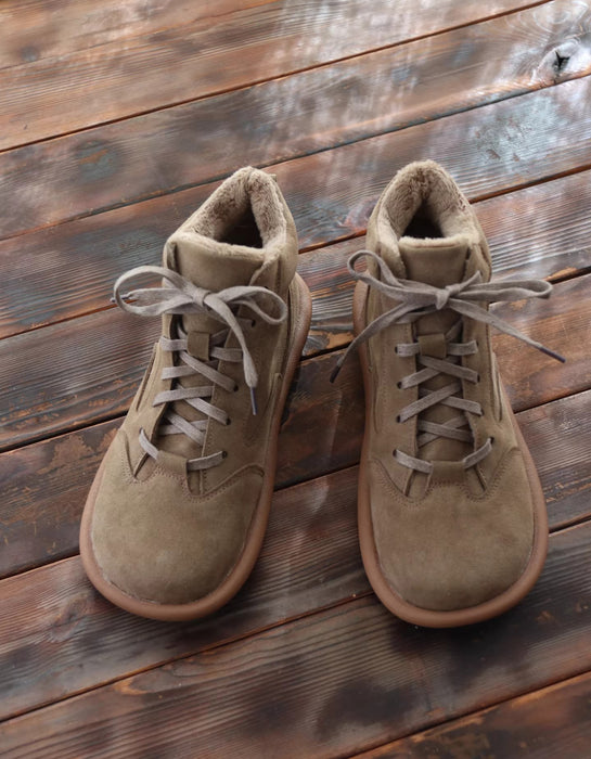 Pair of brown suede boots on a wooden surface