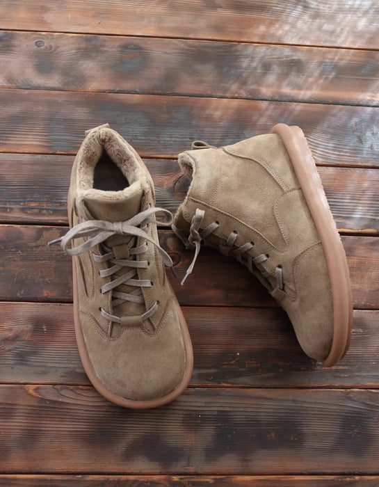 Pair of brown suede boots on a wooden surface
