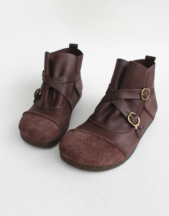 Pair of brown leather boots with buckles on a white background