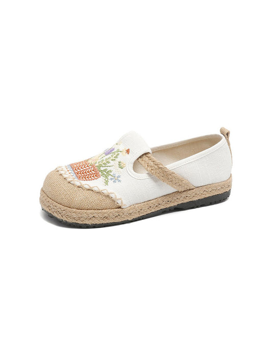 White espadrille shoe with floral embroidery on a white background