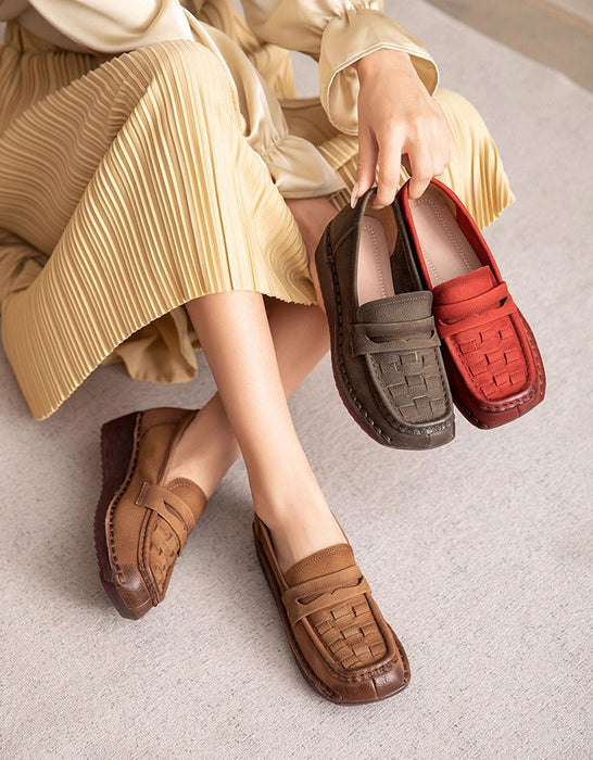 Person holding two pairs of loafers, one brown and one red, on a light-colored floor.