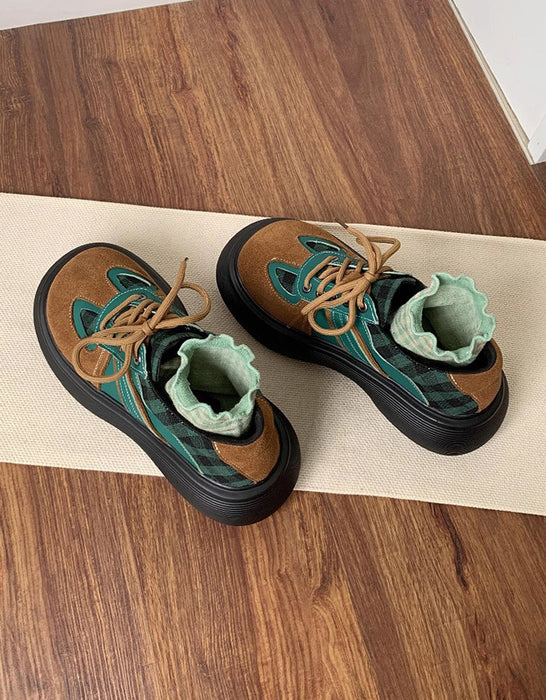 Pair of brown and green shoes on a wooden surface