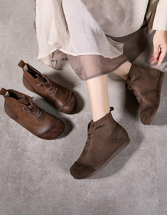 Brown ankle boots worn by a person on a gray surface