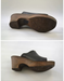 A pair of women's open-toe clogs shown from the side and sole views, featuring a dark brown leather upper and a thick, textured wood-look wedge heel on a light gray background.