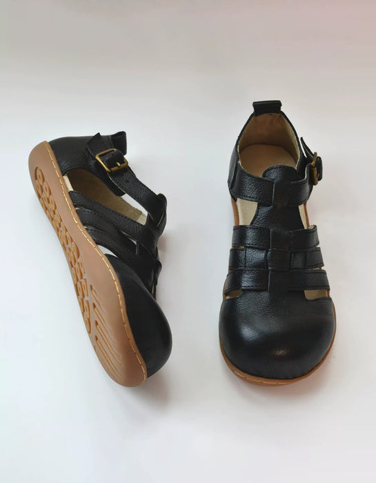 A pair of black leather wide toe box sandals with adjustable straps and a tan sole, shown from both the side and front angles on a light background.