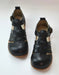 A pair of black leather wide toe box sandals with cutout straps and adjustable buckle straps