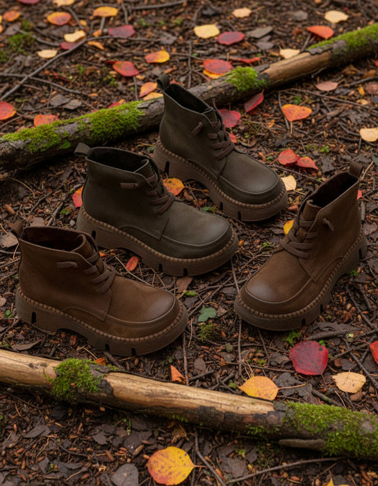 Brown boots on a forest floor with fallen leaves and twigs