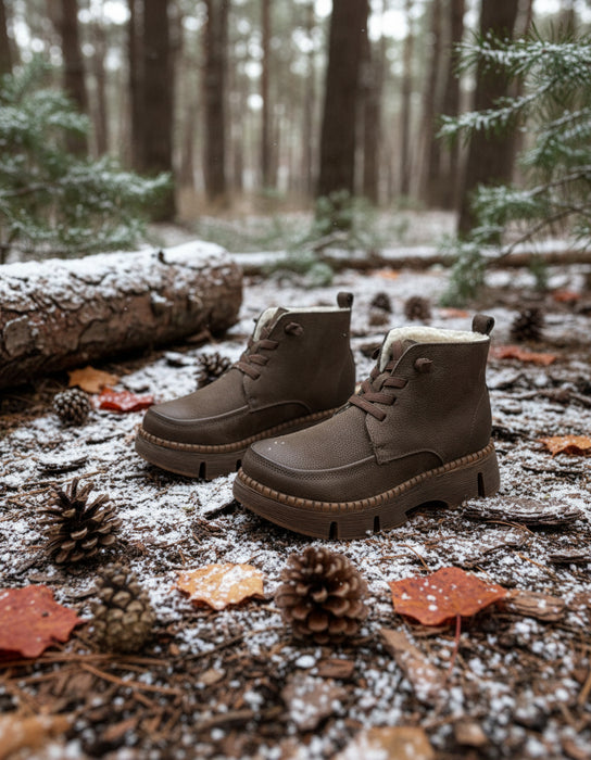 Pair of brown boots with fur lining on a textured gray surface.