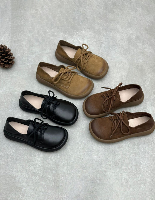 Four pairs of children's lace-up shoes arranged on a light gray textured surface: black leather, tan suede, dark brown leather, and medium brown suede.Women's Comfortable Casual Wide Toe Box Retro Flat Shoes